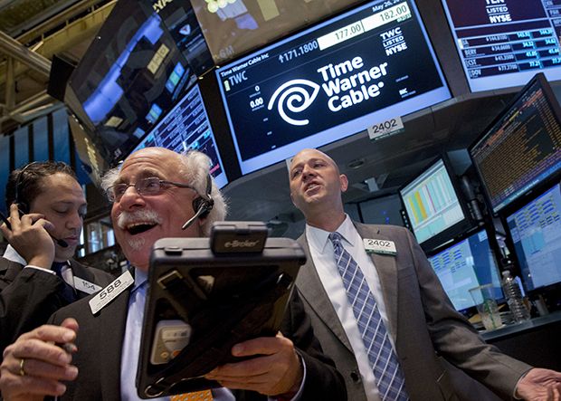 Traders work at the post where Time Warner Cable is traded on the floor of the New York Stock Exchange. Charter Communications, offered to buy Time Warner Cable