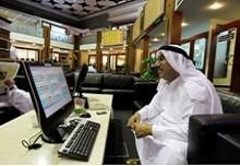 An investor monitors a stock exchange information screen on the trading floor at the Dubai Financial Market 