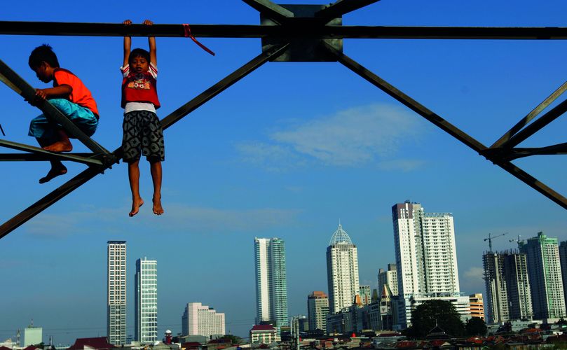 Children play at an electricity pylon in Jakarta