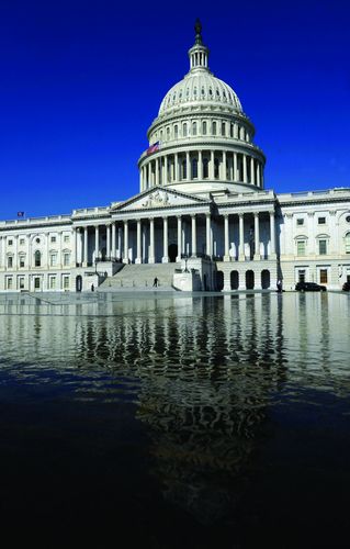 The U.S. Capitol dome is seen atop a nearby reflecting pool in Washington