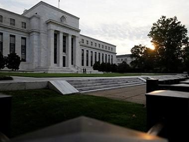 The sun rises to the east of the US Federal Reserve building in Washington