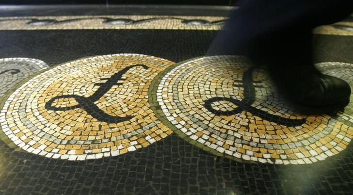 An employee is seen walking over a mosaic of pound sterling symbols