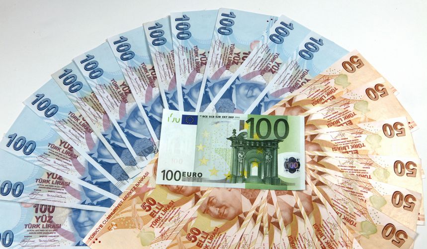 100 euro banknote laying on various denomination Turkish lira banknotes