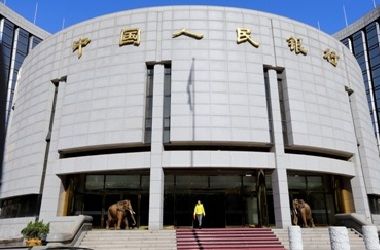 A woman walks out of the headquarters of the People's Bank of China (PBOC) in Beijing