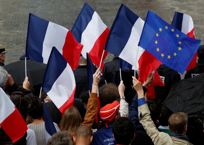 People holds French and European flags