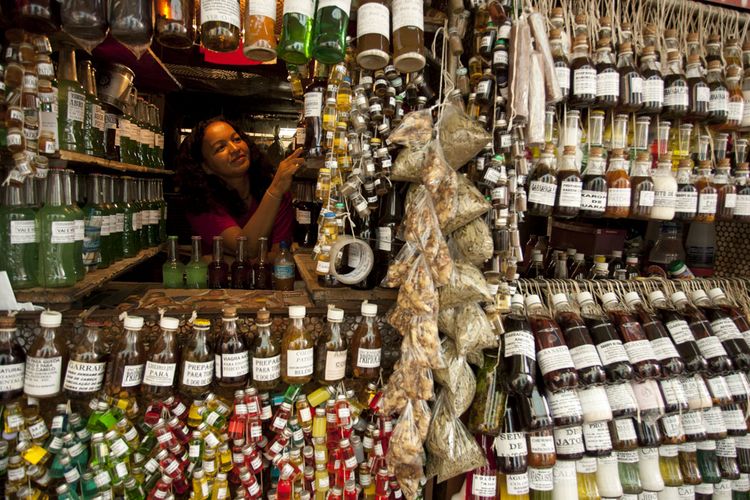 A shopkeeper arranges her bottles of perfumes and oil made from fruits and plants that grow in the A