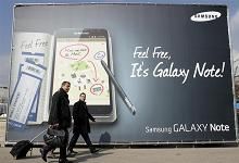 Visitors walks past a Samsung Galaxy tablet advertisement during the Mobile World Congress in Barcel