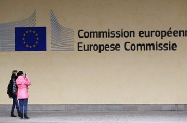 Two women stand at the entrance of the European Commission headquarters in Brussels