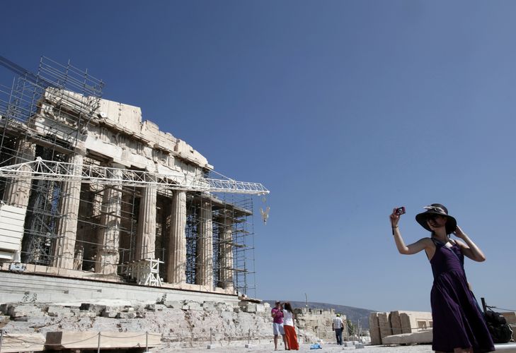 A tourist takes pictures in front of the Parthenon temple at the Acropolis hill 