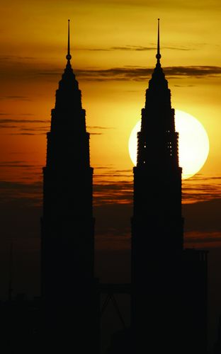 The sun sets behind the Petronas Twin Towers in Kuala Lumpur 