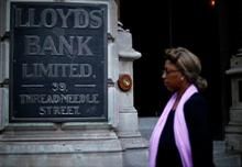 A woman walks past a branch of Lloyds Bank in the City of London 