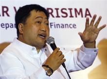 Philippine Finance Secretary Cesar Purisima gestures as he answers questions during a meeting with b