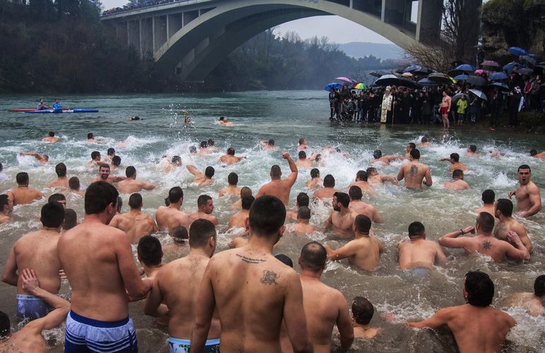 Believers jump into the Ribnica river