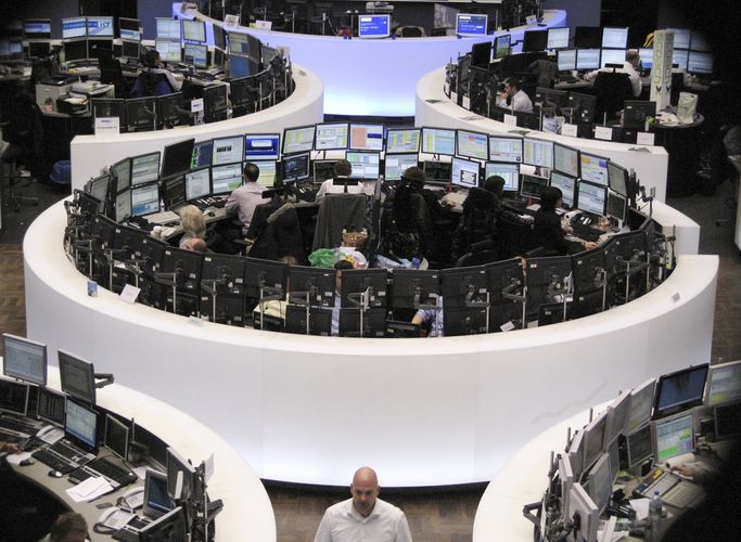 Traders are pictured at their desks at the Frankfurt stock exchange. 