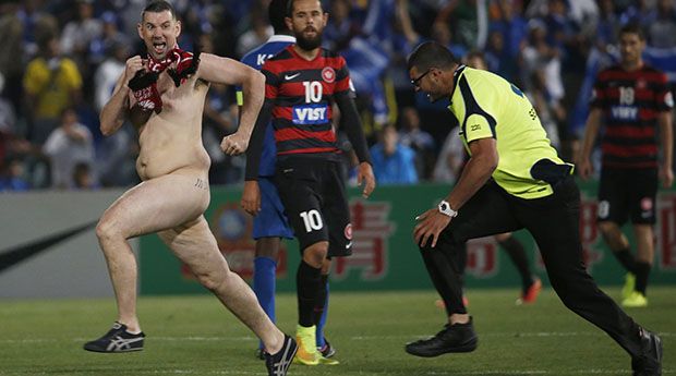 A streaker runs across the pitch as a security guard prepares to tackle him during the Asian Champions League final first-leg soccer match