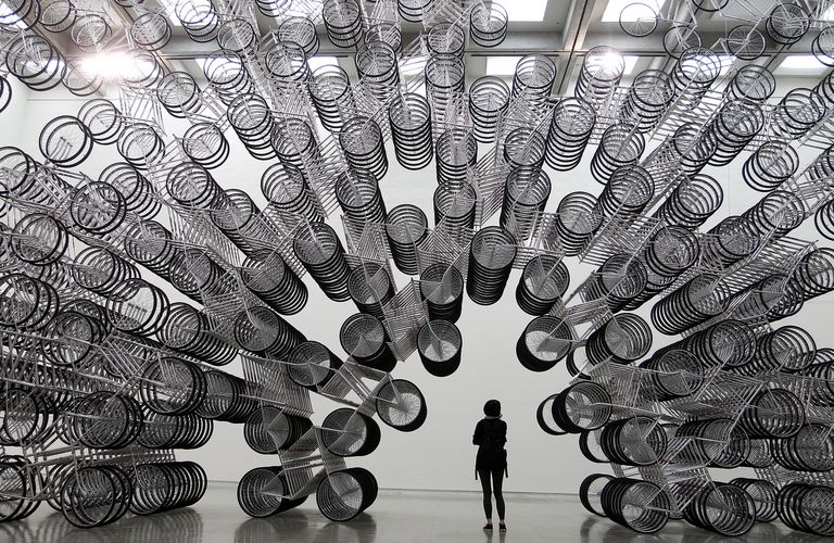 A woman looks at an art installation named “Forever Bicycles” by dissident Chinese artist Ai Weiwei 