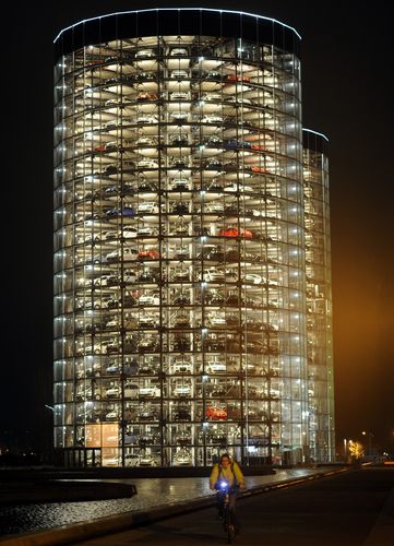 A cyclist passes the Autostadt delivery towers of German carmaker Volkswagen in Wolfsburg.