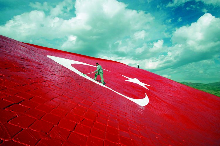 Workmen put the finishing touches on a giant Turkish flag painted on stones 