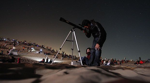 A man uses a telescope to observe the firmament in the dunes of Samalayuca on the outskirts of Ciudad Juarez