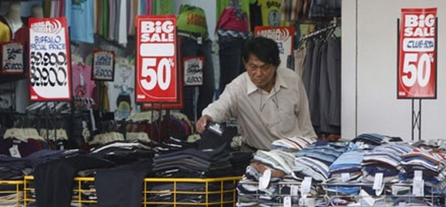 A man searches for discounted clothes at a shop in Jakarta. 