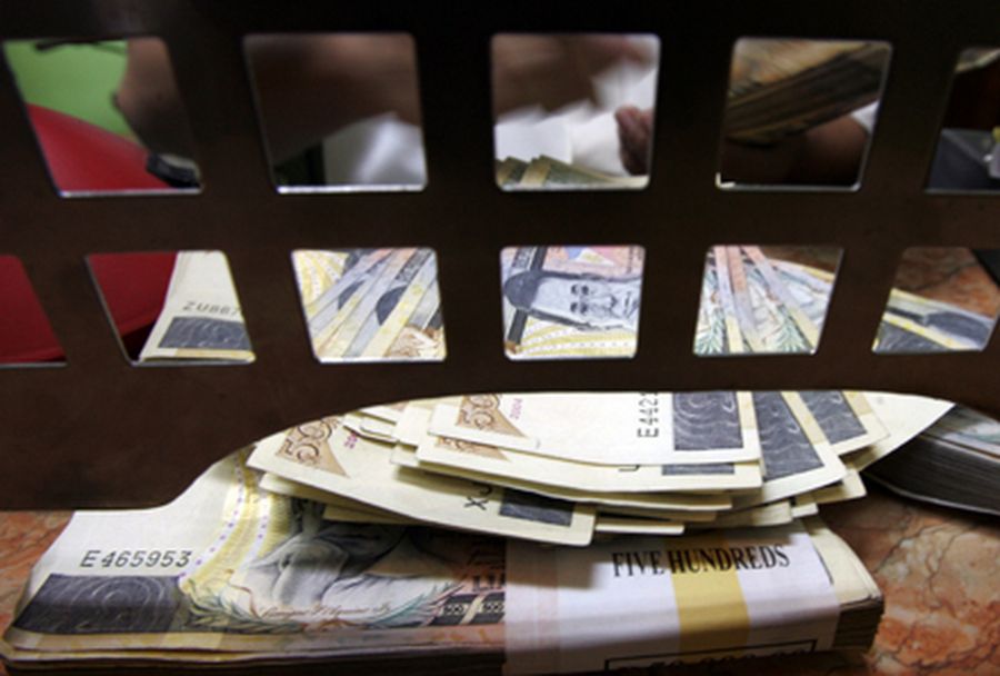 A Filipino worker counts 500 peso bills inside a money changer in Manila