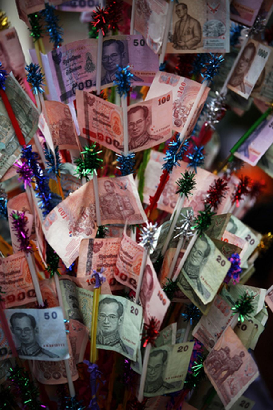 Thai baht banknotes are left by Buddhist believers attending an alms offering ceremony in Bangkok's 