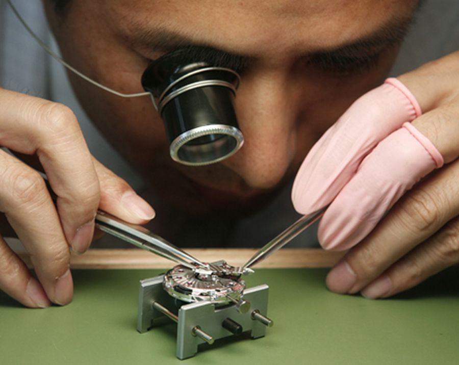 Focusing on precision – a craftsman examines a watch at Beijing.