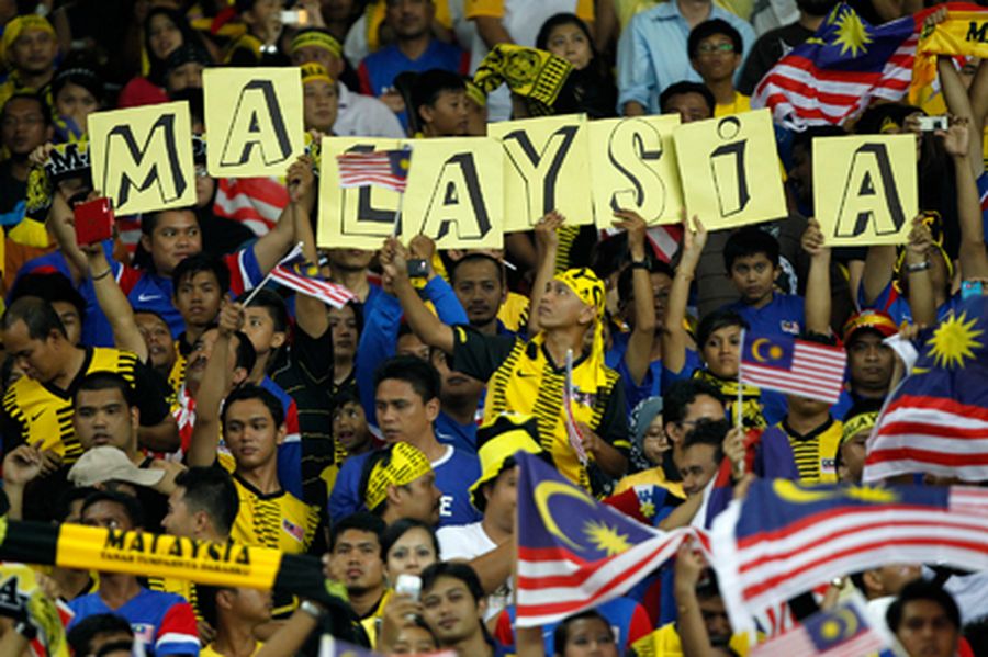 Malaysian fans hold placards during their 2014 FIFA World Cup qualification soccer match against Sin