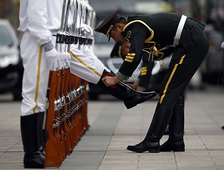 Members of an honour guard have their boots clean as they get ready for a welcoming ceremony.