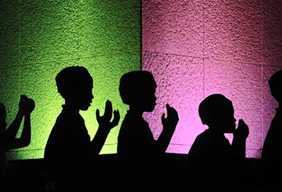 Young Malaysian muslims are silhouetted as they recite night prayer outside mosque in Kuala Lumpur.