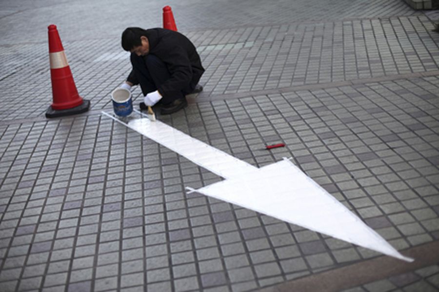 A worker paints a road sign inside a residential compound in the centre of Shanghai