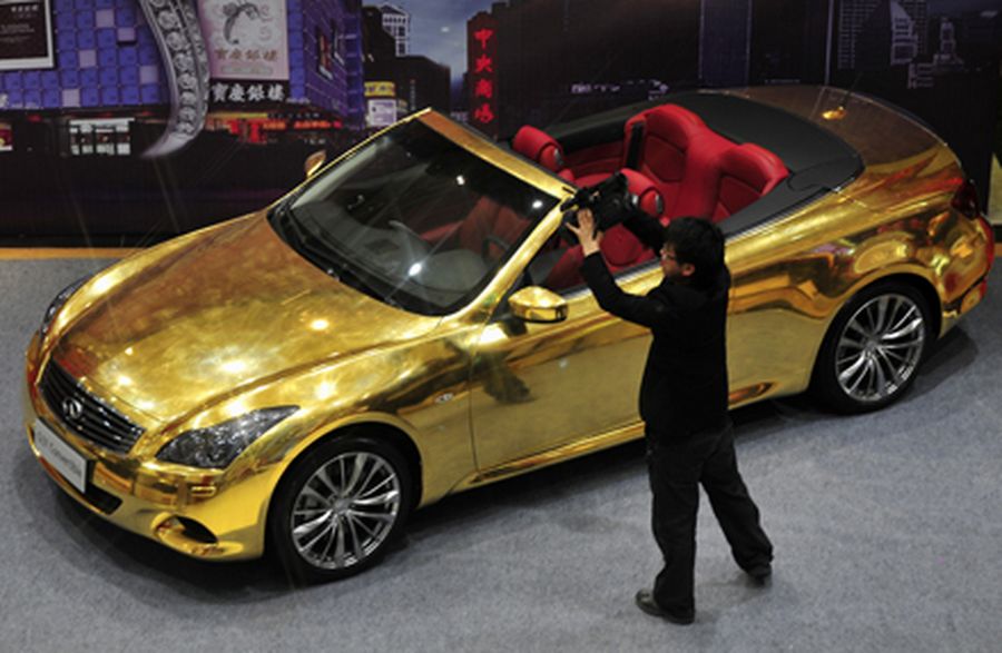 A man films a gold-plated Infiniti G37 at a jewelry store in Nanjing,