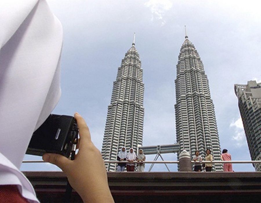 A Malaysian takes a souvenir picture of the Petronas Twin Towers in Kuala Lumpur.