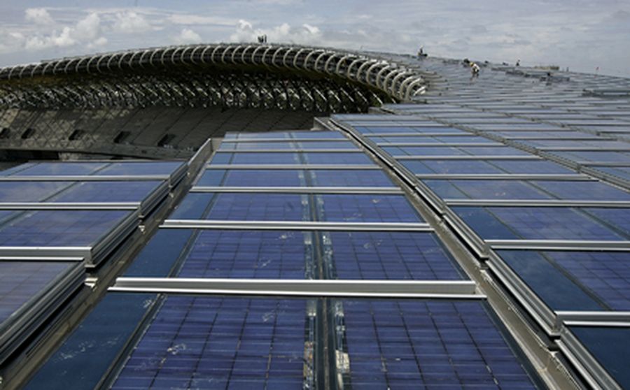 People work on the roof of the main stadium of the World Games 2009, which is made of solar panels, 